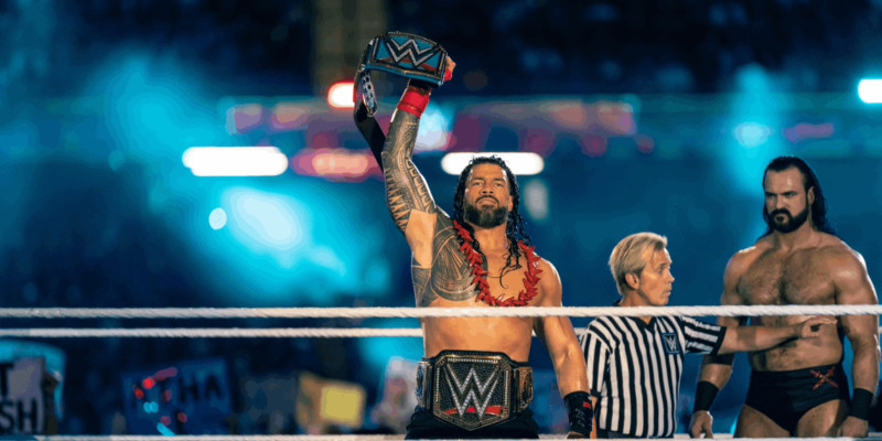 Roman Reigns holds up his WWE title